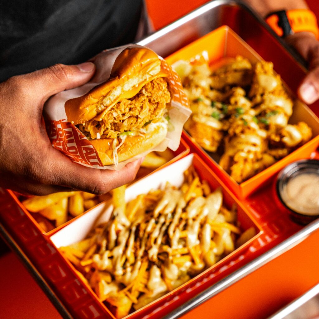 Mouthwatering fast food meal featuring a juicy burger and loaded fries on a vibrant tray.